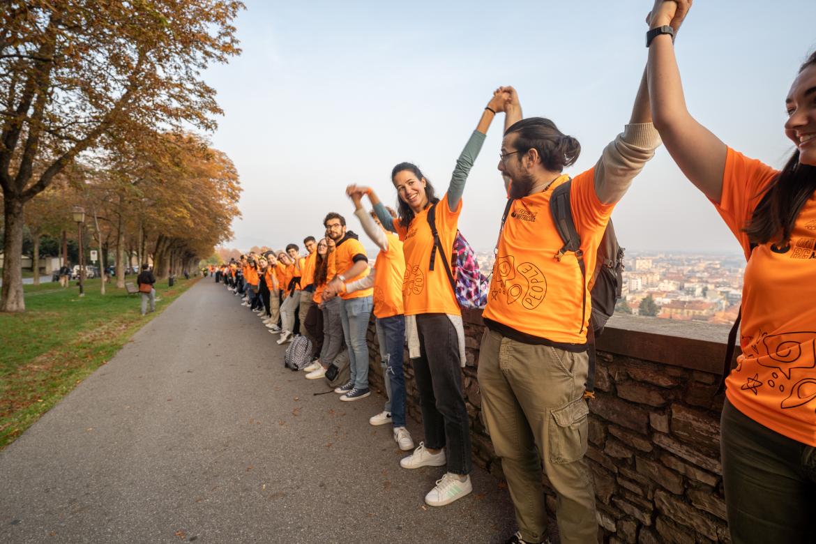 Studenti che abbracciano le mura durante la festa delle matricole