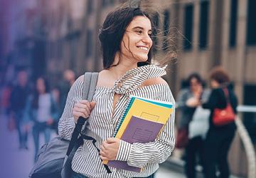 Studentessa che cammina con libri