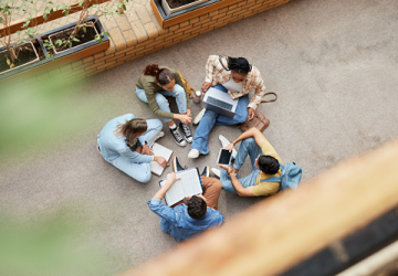 Studenti seduti per terra con PC